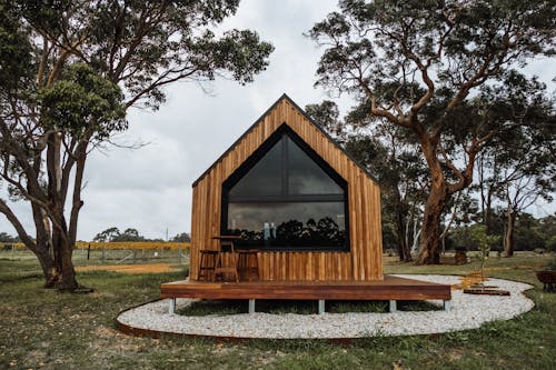 A wooden couch designed for outdoor living solutions, showcasing natural materials and inviting comfort in an outdoor setting.